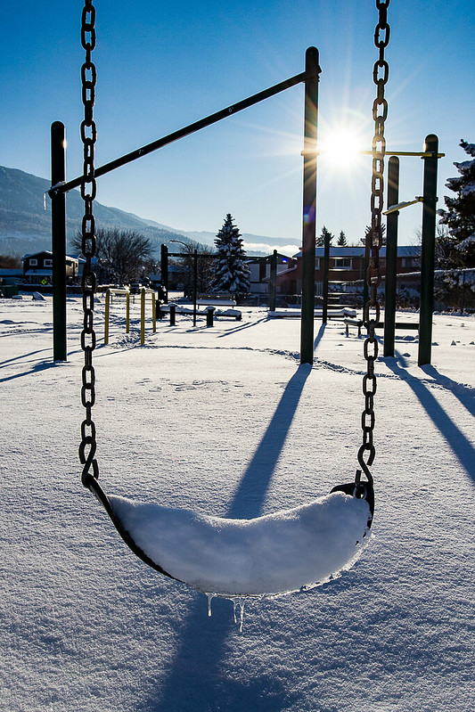 swing at playground covered in snow