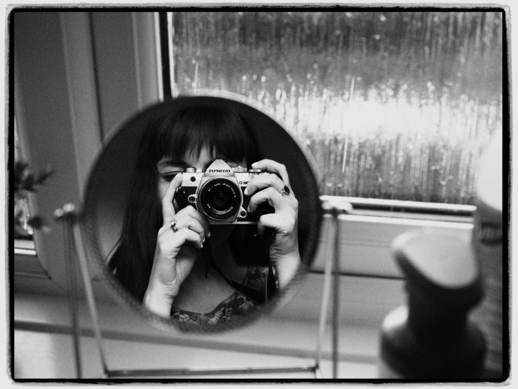 Woman Taking Photo of Herself in Small Mirror self-portraits