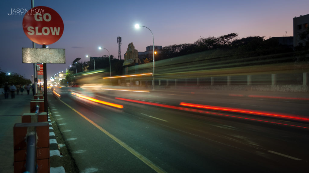 Cars speed past a Go Slow sign in Chennai