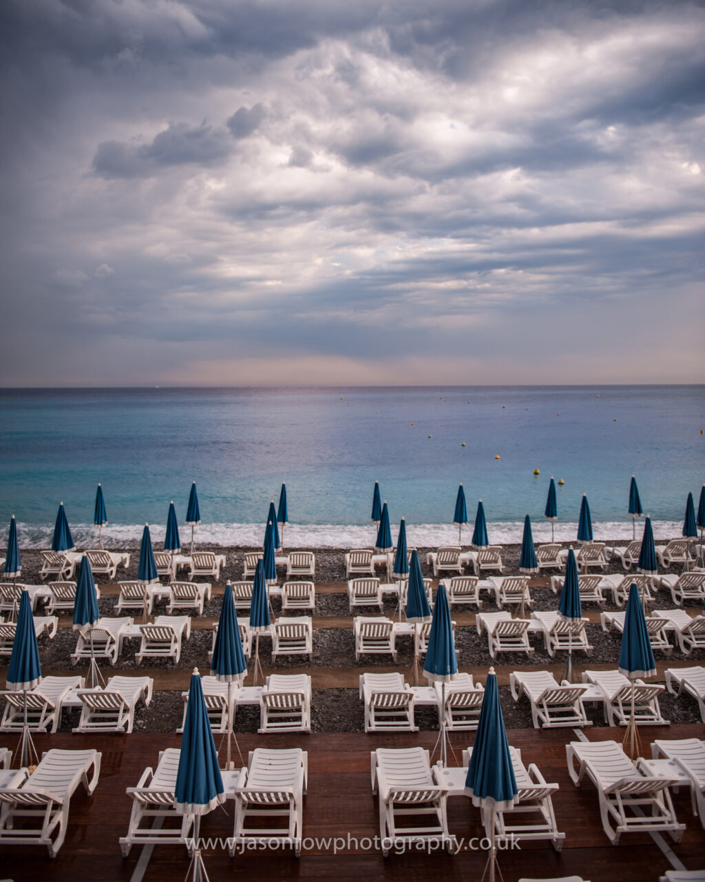 A deserted beach full of sun loungers in the off season in Nice, France 