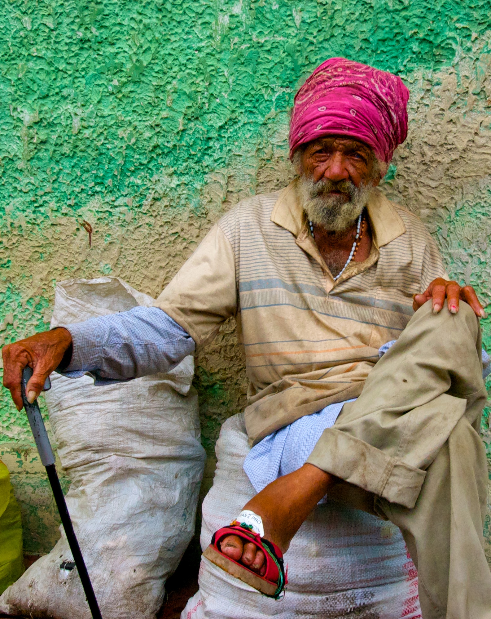 Local man in front of a turquoise background in the markets of Granada.