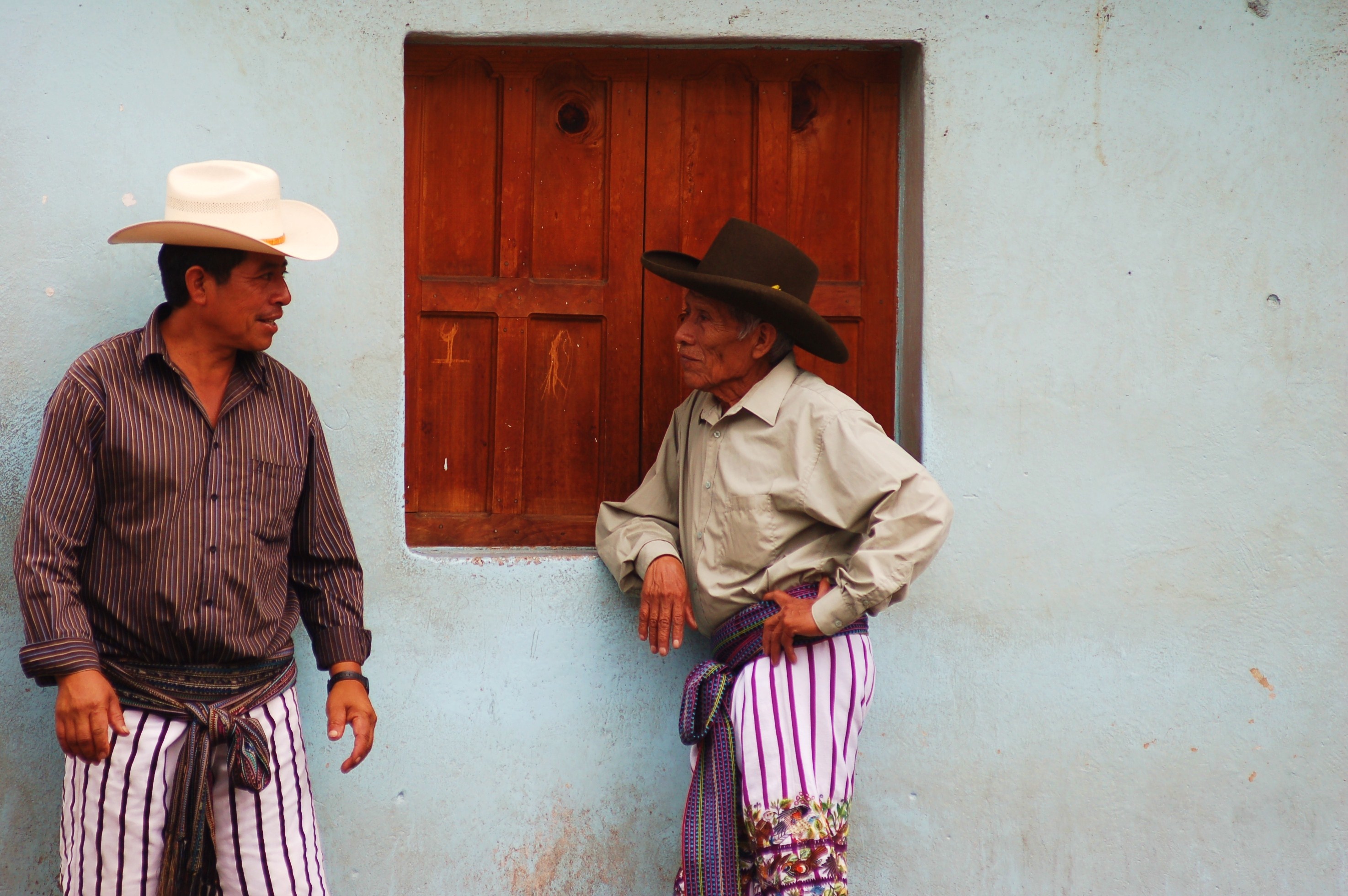 Men conversing at a market on Lake Atitlan.