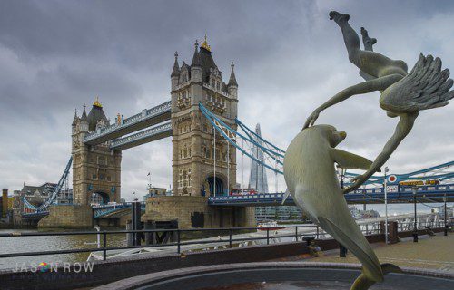 A daytime view of Tower Bridge, with David Wynnes's statue of Girl with Dolphin, in the foreground