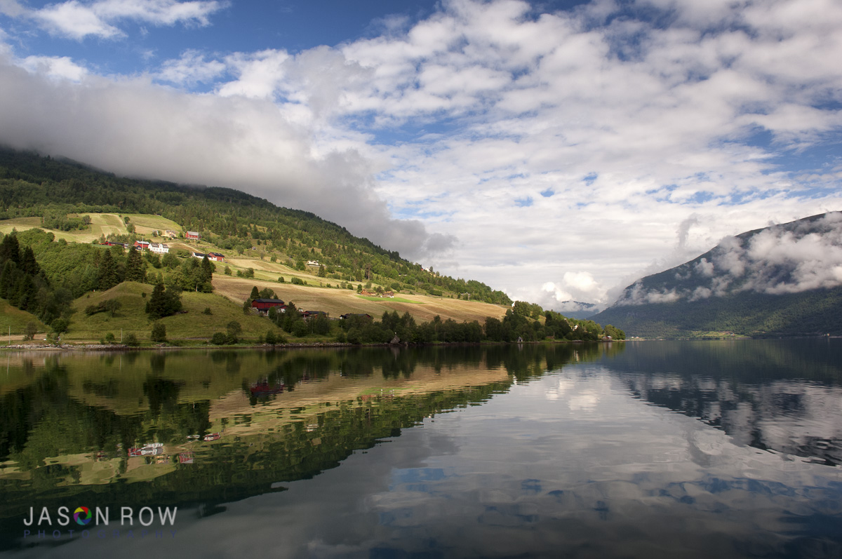 The near still water of dawn in the Fjords. By Jason Row Photography