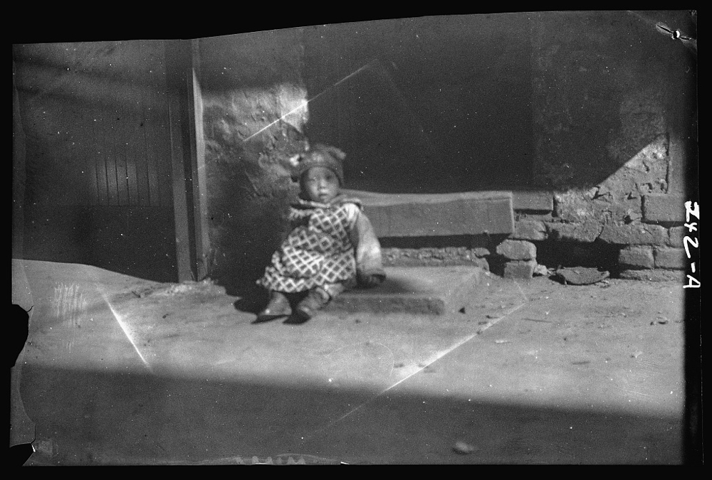 Small child sitting on a doorstep, Chinatown, San Francisco