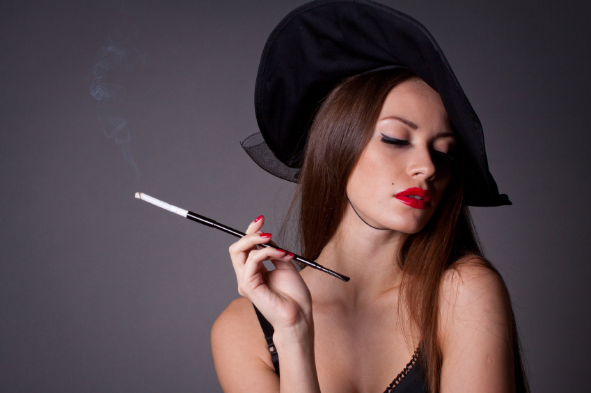 Beautiful elegant woman in hat with cigarette