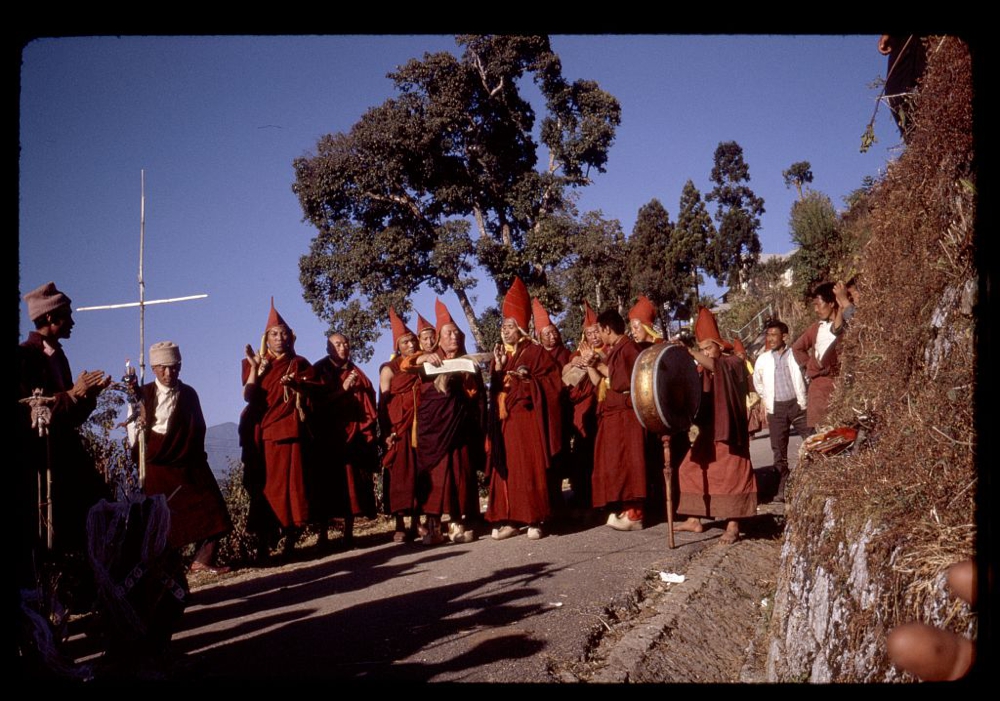 Lamas praying as they walk down the mountain to perform religious sacrifice, Sikkim