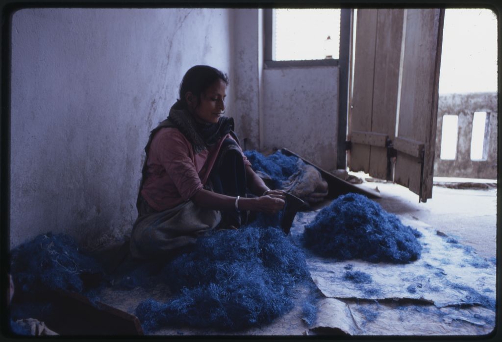 Nepalese woman working with blue dyed wool, Sikkim