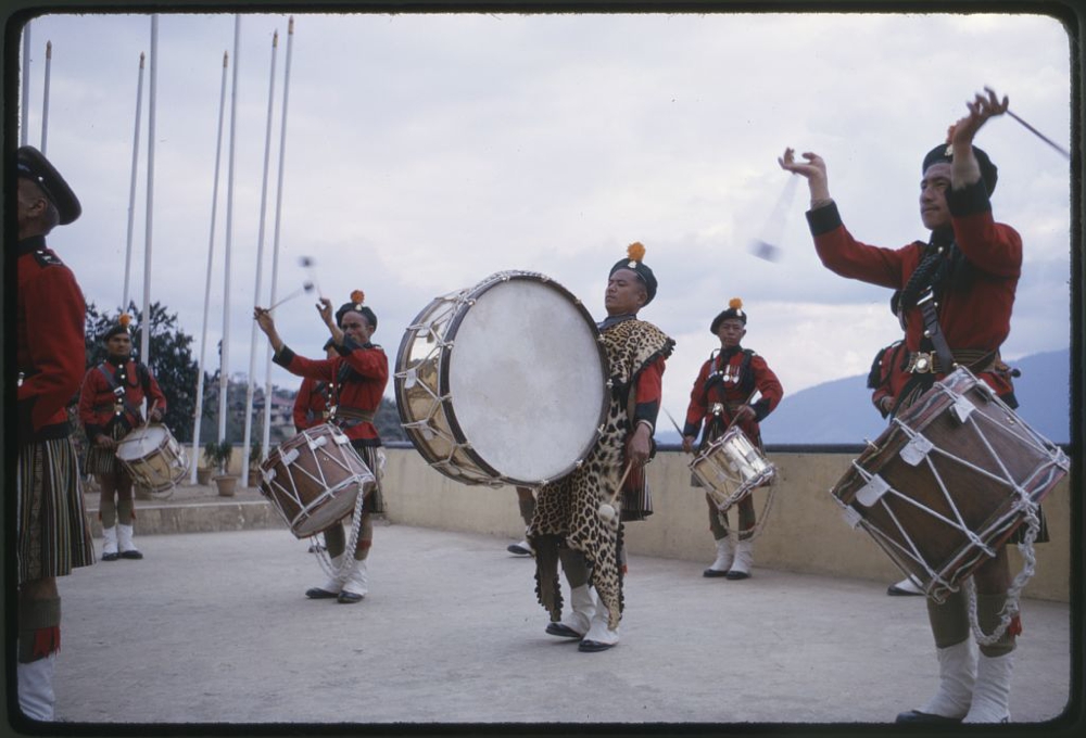 Photograph shows palace guards playing drums during the coronation ceremonies for Palden Thondup Namgyal, King of Sikkim, Gangtok, Sikkim