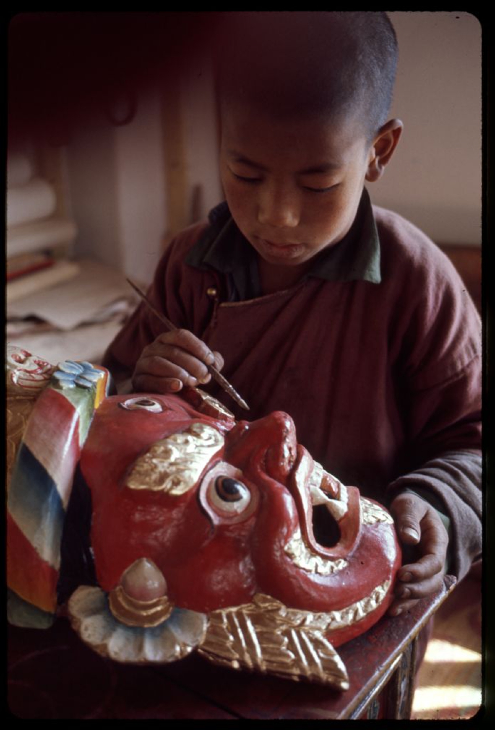 Sikkimese boy painting a mask