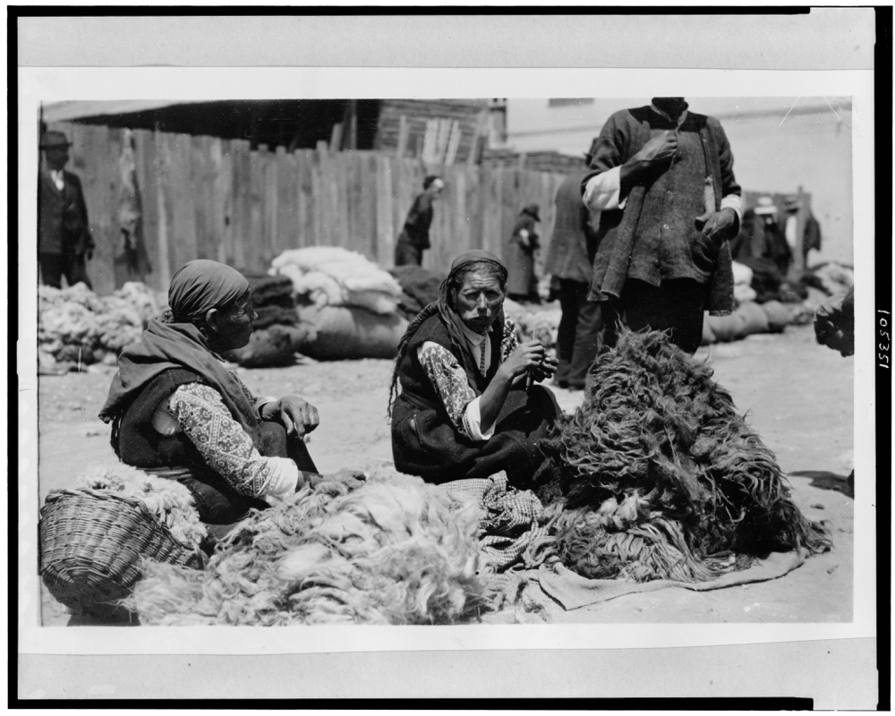 Bulgarian peasant women in market place, with piles of black and white wool