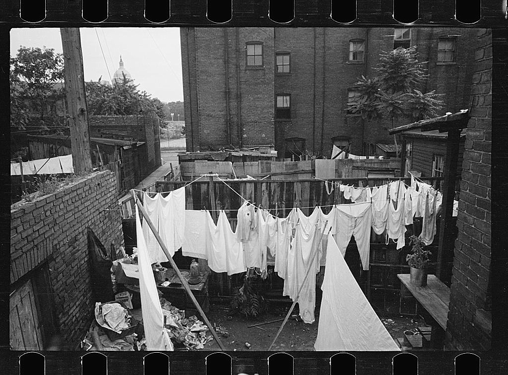 The Capitol can be seen in the background of this backyard slum scene