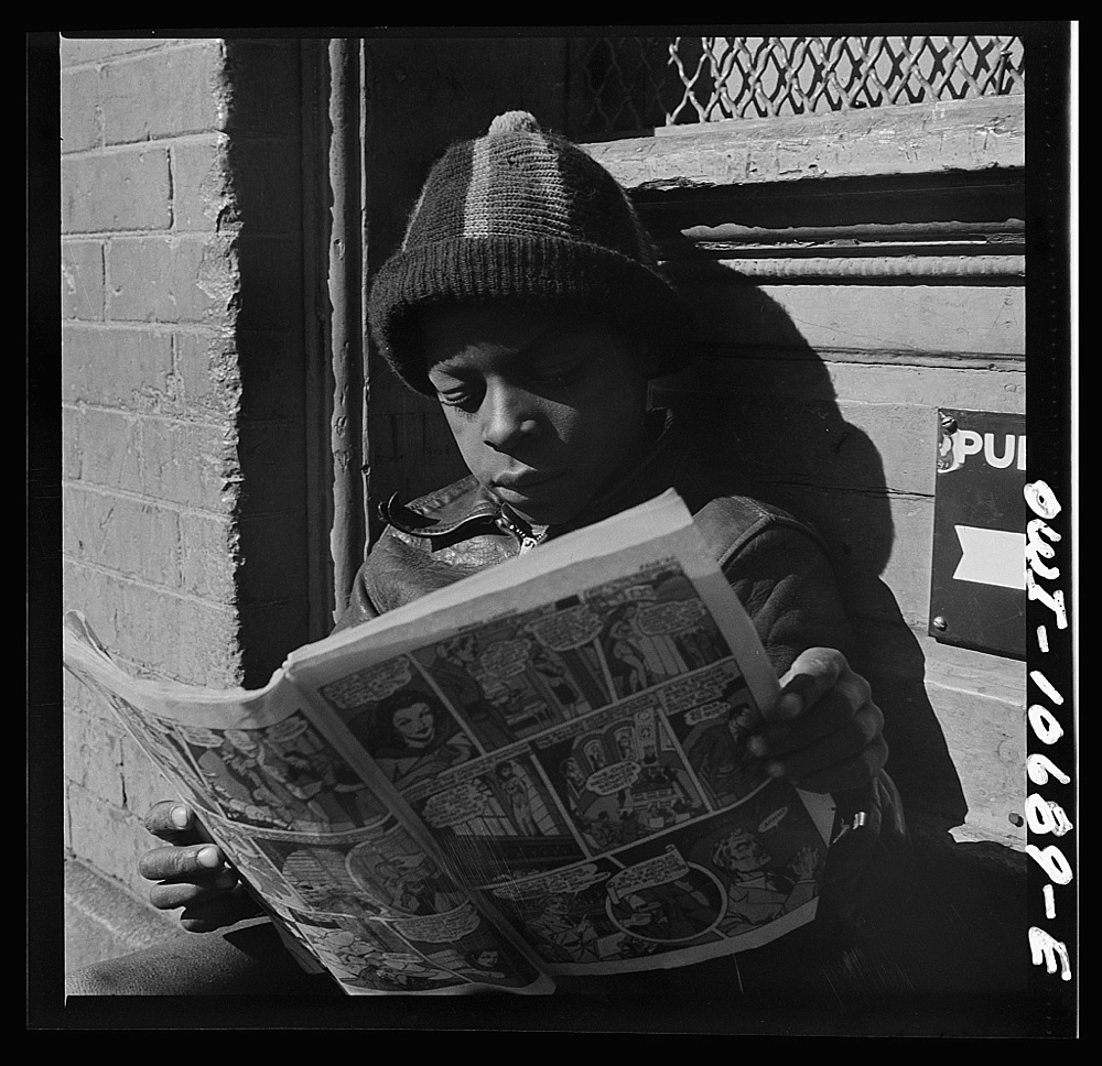 Washington, D.C. Negro youth reading a funny paper on a door step