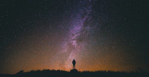 a person standing in front of a starry night sky