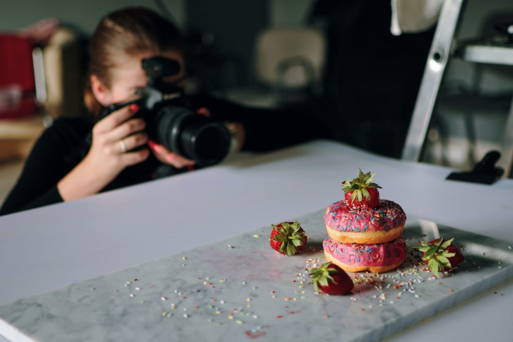 woman taking photo of donuts