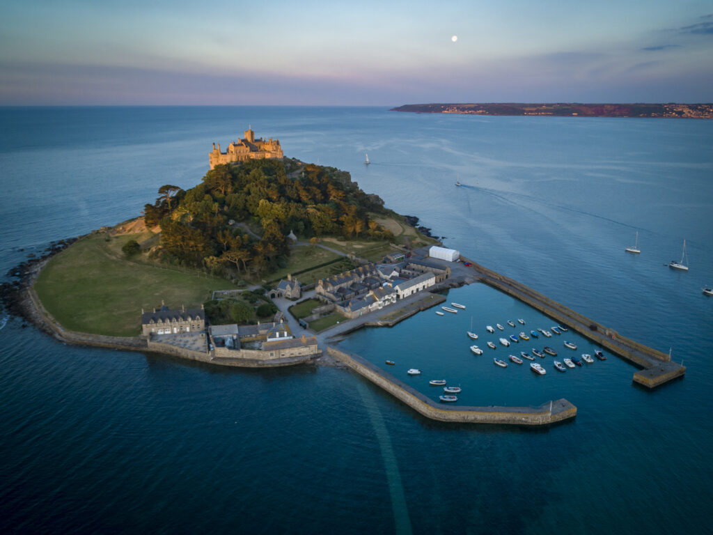 St Michaels Mount Cornwall behind during beautiful golden hour with yachts in foreground