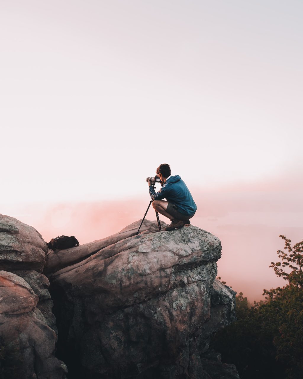 photographer with tripod on the rock