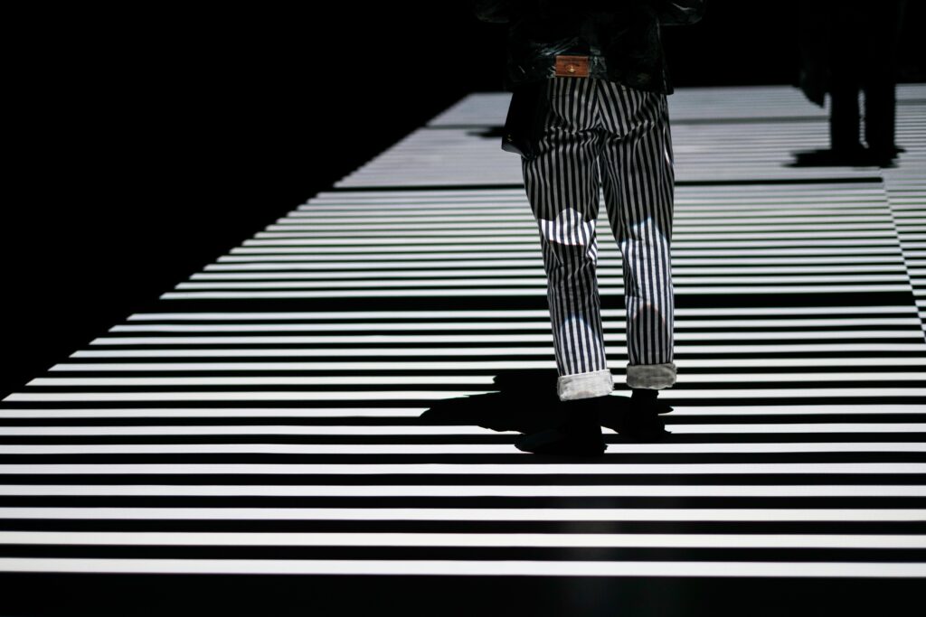 Person in stripped trousers crossing on a zebra crossing decisive moment