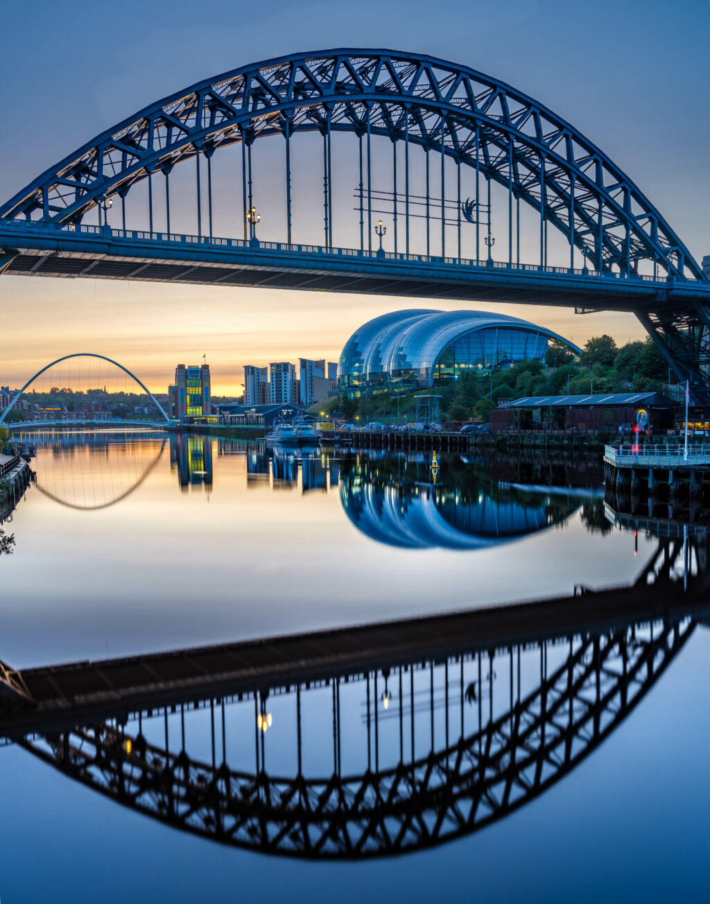 The Tyne Bridge in Newcastle England on a calm still morning with beautiful reflections