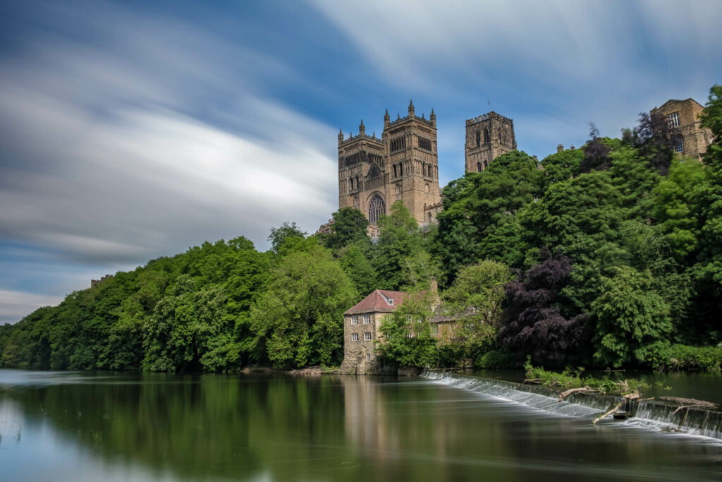 Durham Cathedral and weir on summer day shot with long exposure and cloud motion