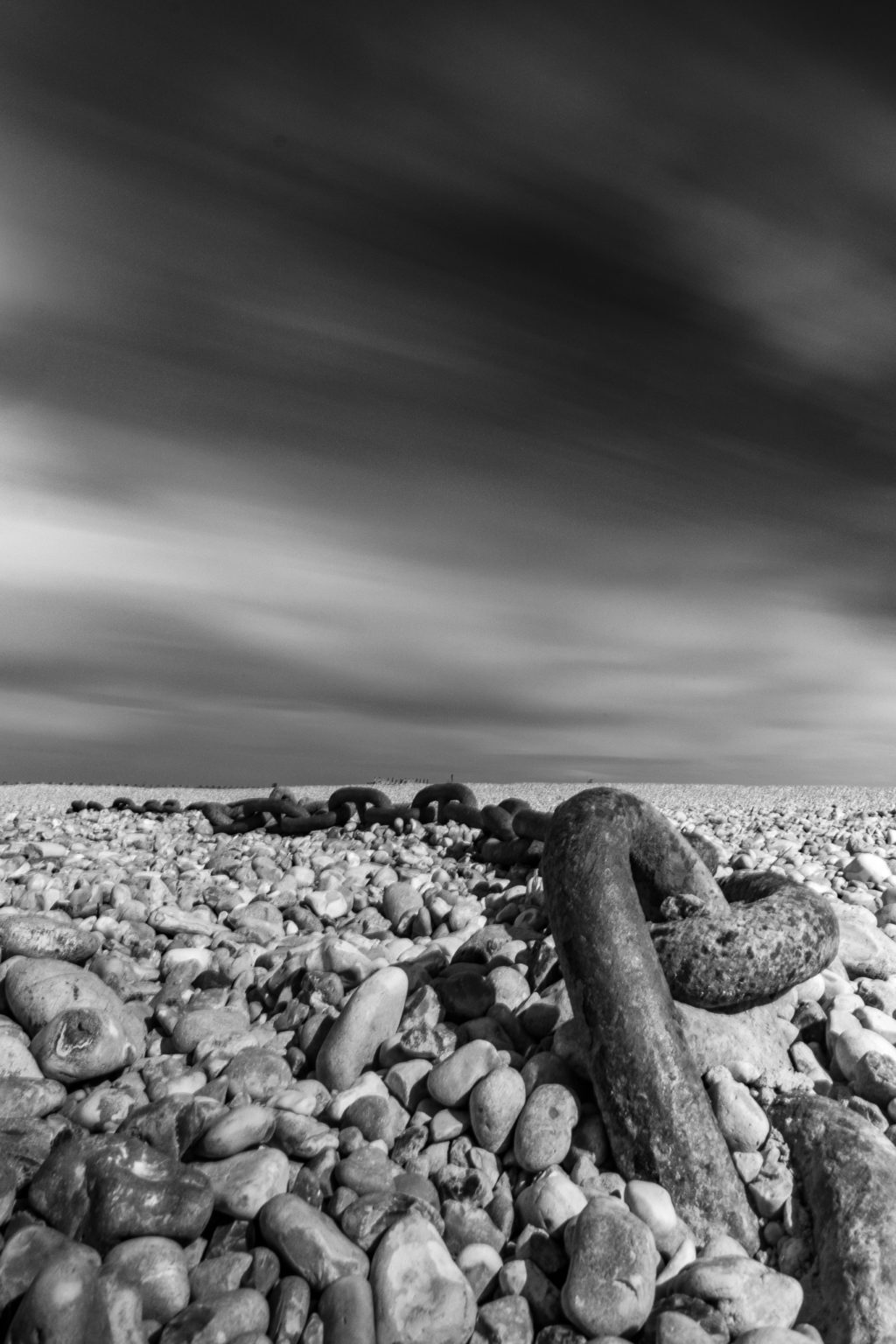 Long exposure image of chains on a stone beach images tell story