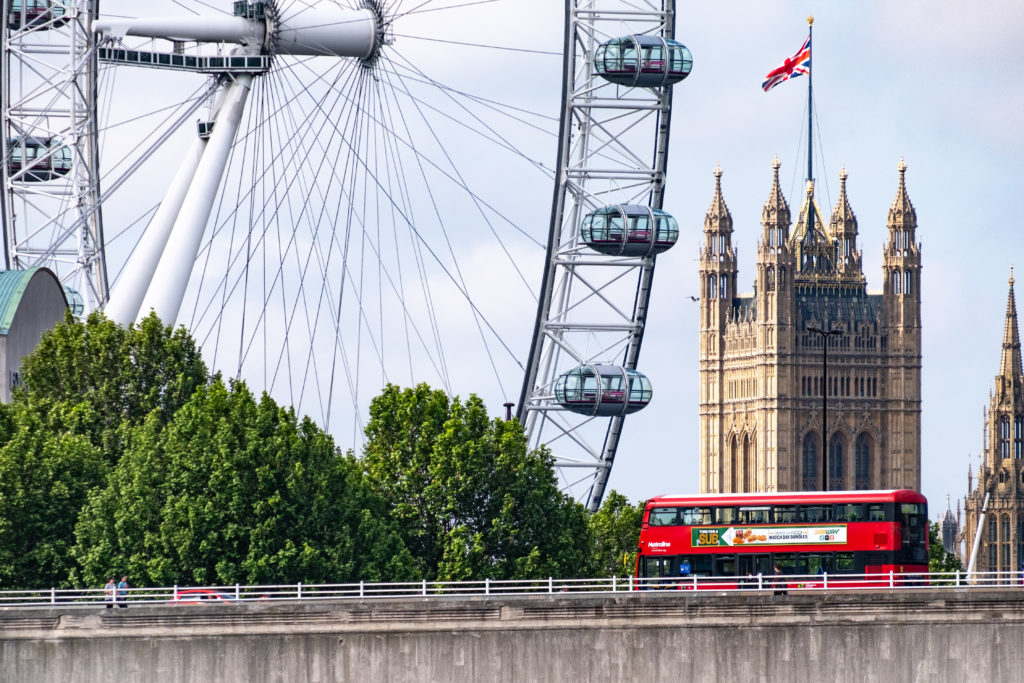 London bus crosses Waterloo Bridge with London Eye behind
