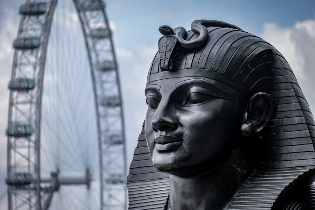 Sphinx on London's embankment with London Eye behind.