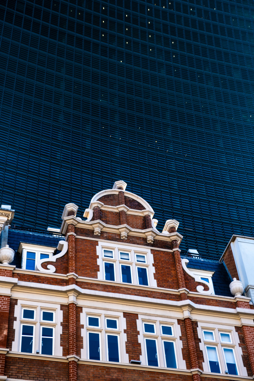 Victorian building juxtaposed against modern London skyscraper. 