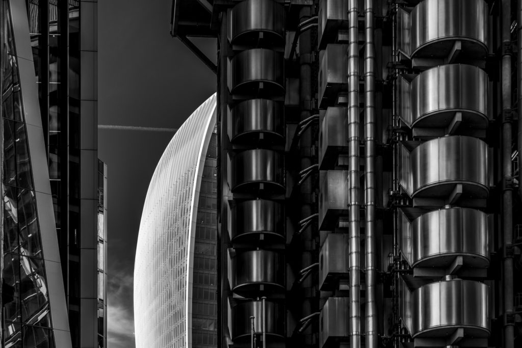 The Walkie Talkie Building seen through a gao between Lloyds of London and Willis Towers Watson on a clear summer day