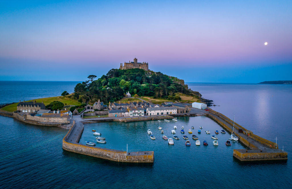 Mid level drone shot of St Michaels Mount Cornwall with the full moon behind