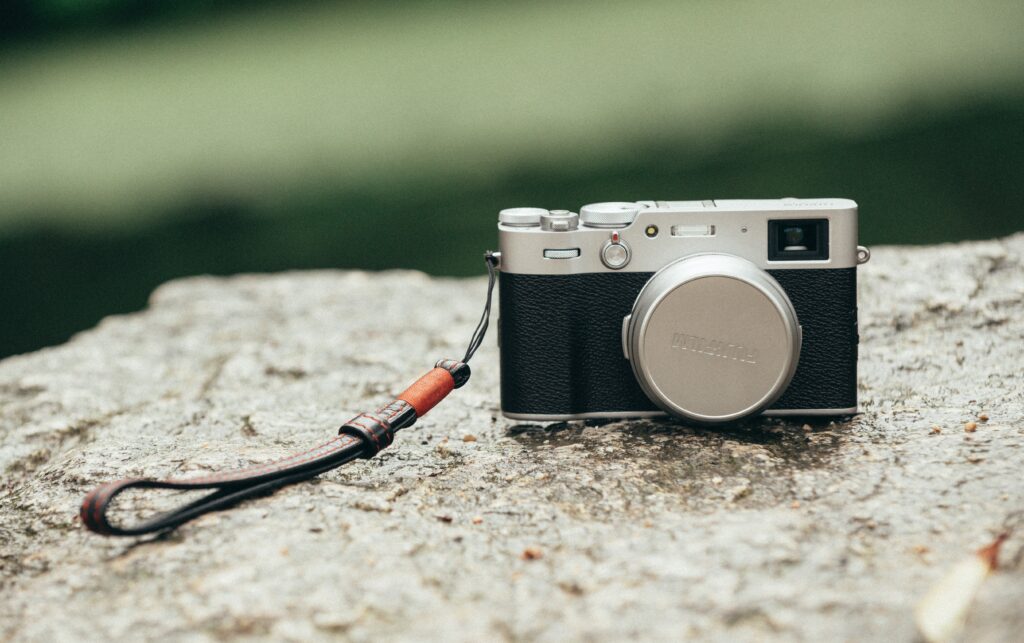 A Fuji X100 series camera on a rock
