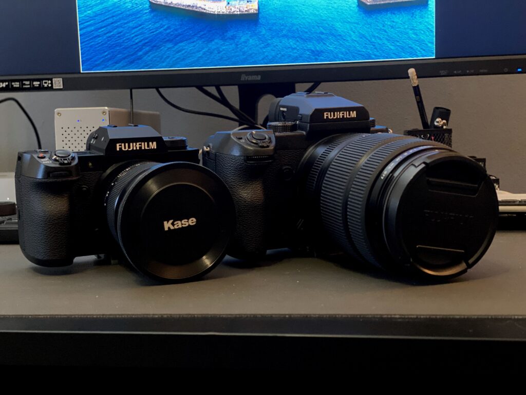 Two Fujifilm cameras beside each other. One os APS-C the other medium format. 