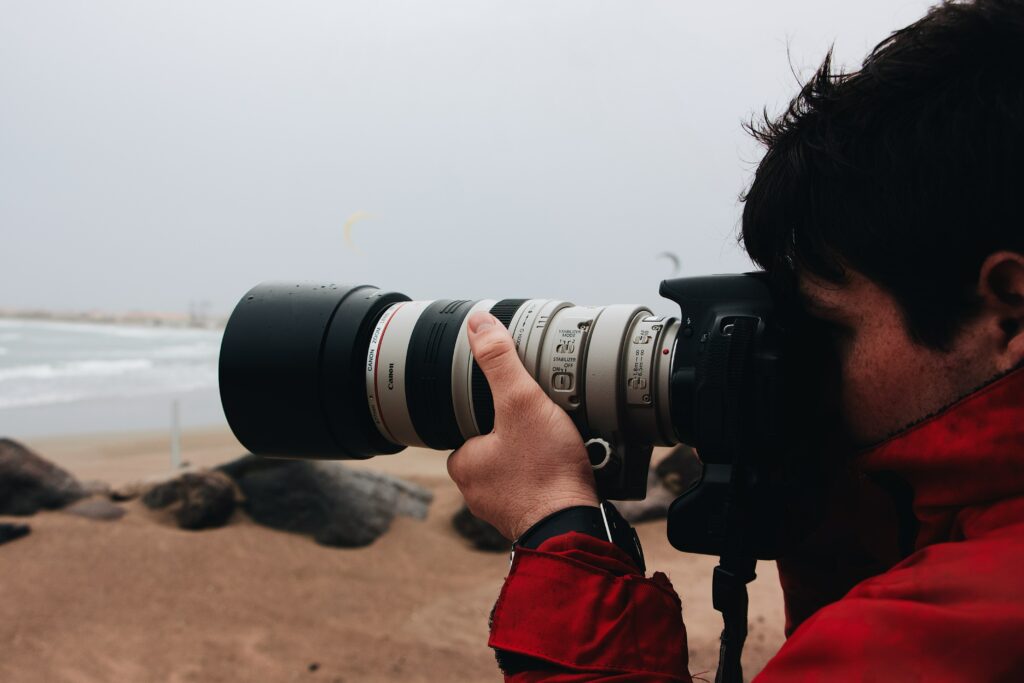 Photographer with large, white telephoto lens. 