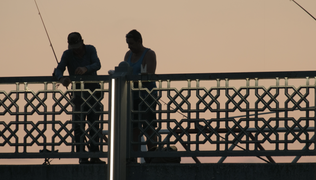 Fishermen on the Galata Bridge, Istanbul during sunset. 