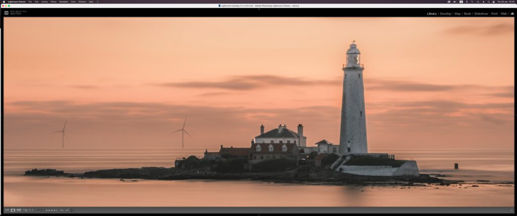 Screenshot of a lighthouse being edited in Lightroom on a widescreen monitor