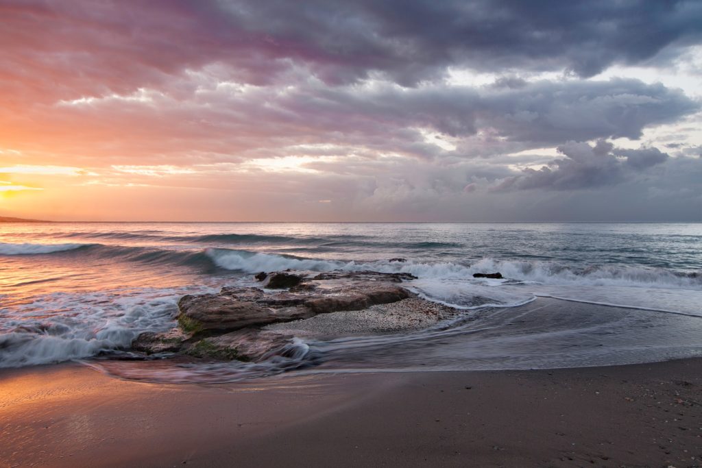 a beach with waves crashing against rocks