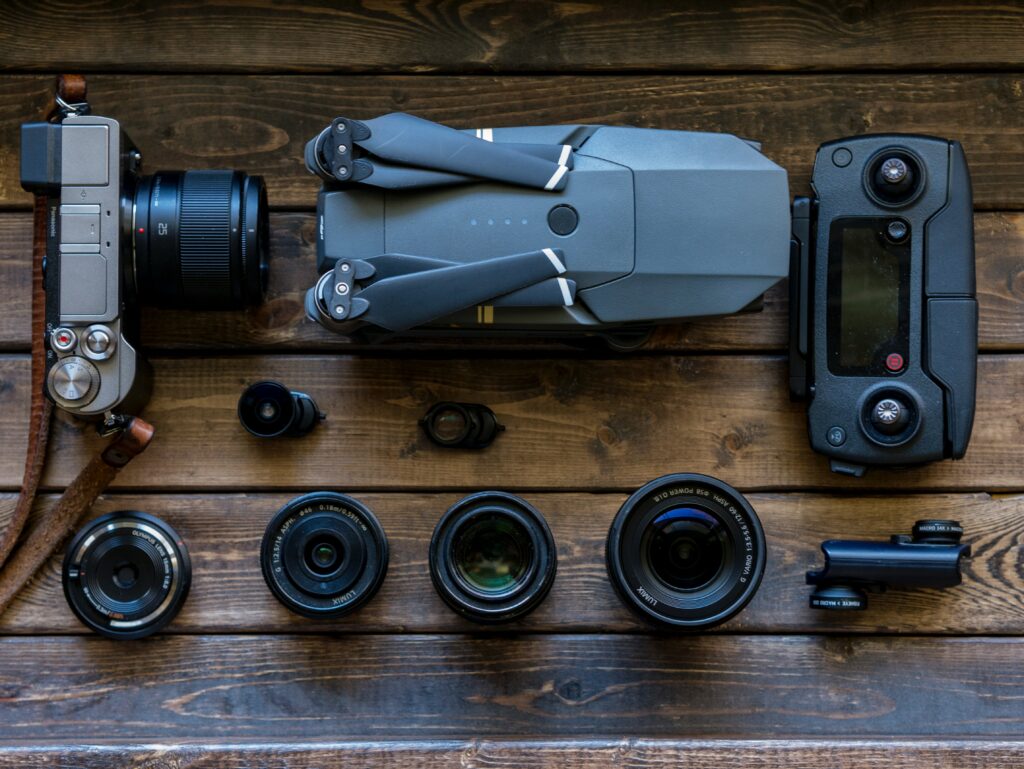 Drone, camera and lenses arranged on a desk.