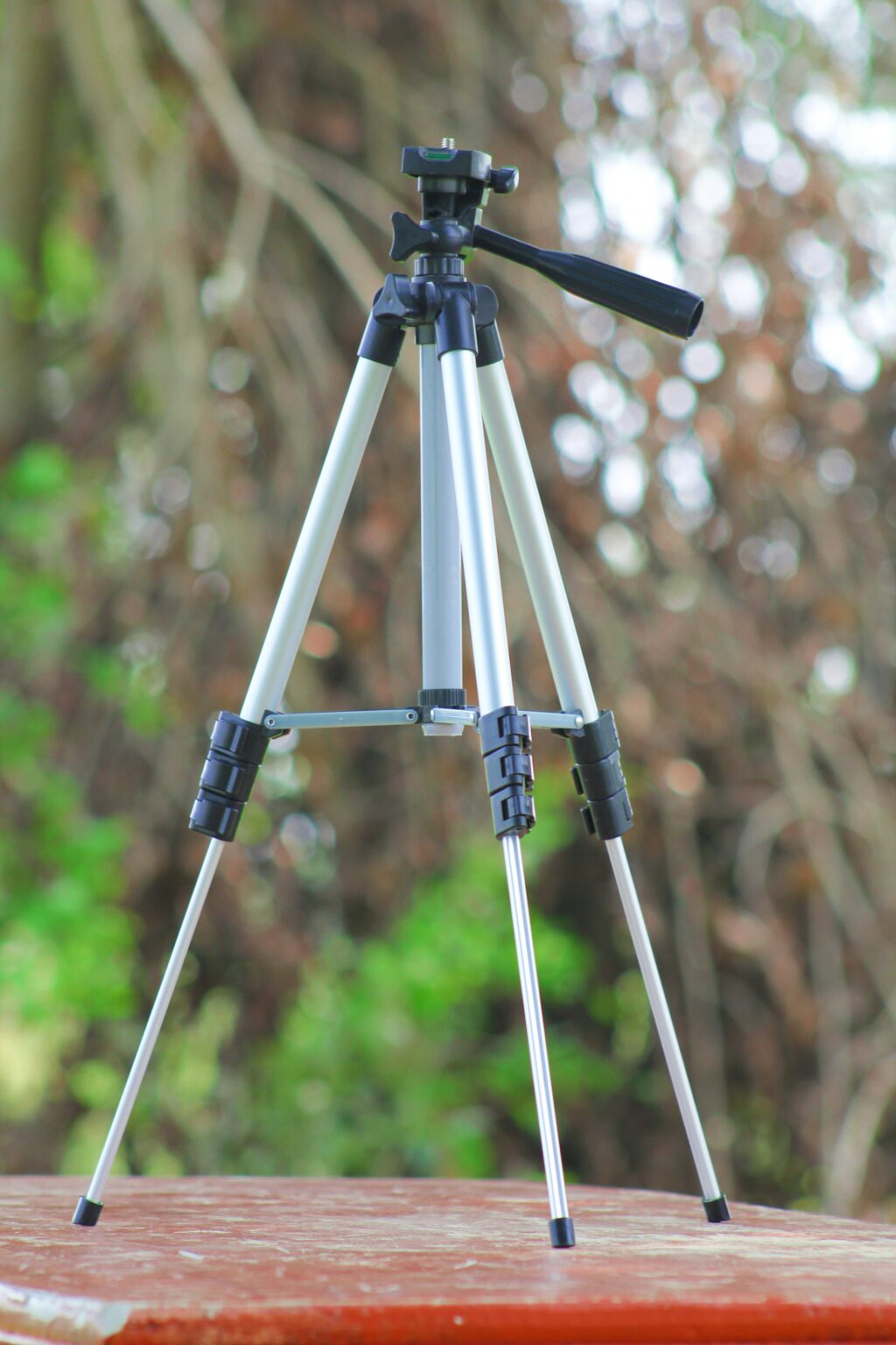 A cheap looking tripod with legs extended 