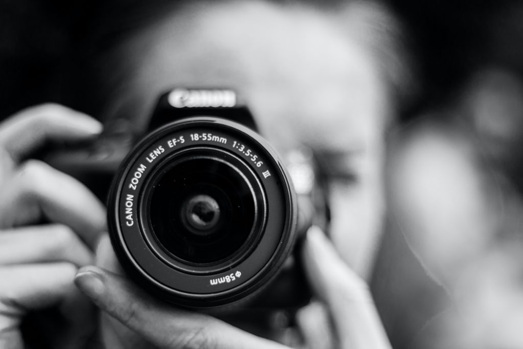 Person holding a camera ready to shoot.
