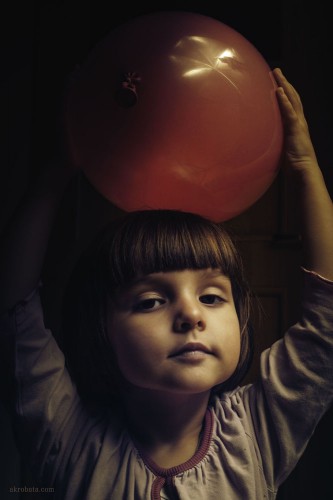 child holding red balloon