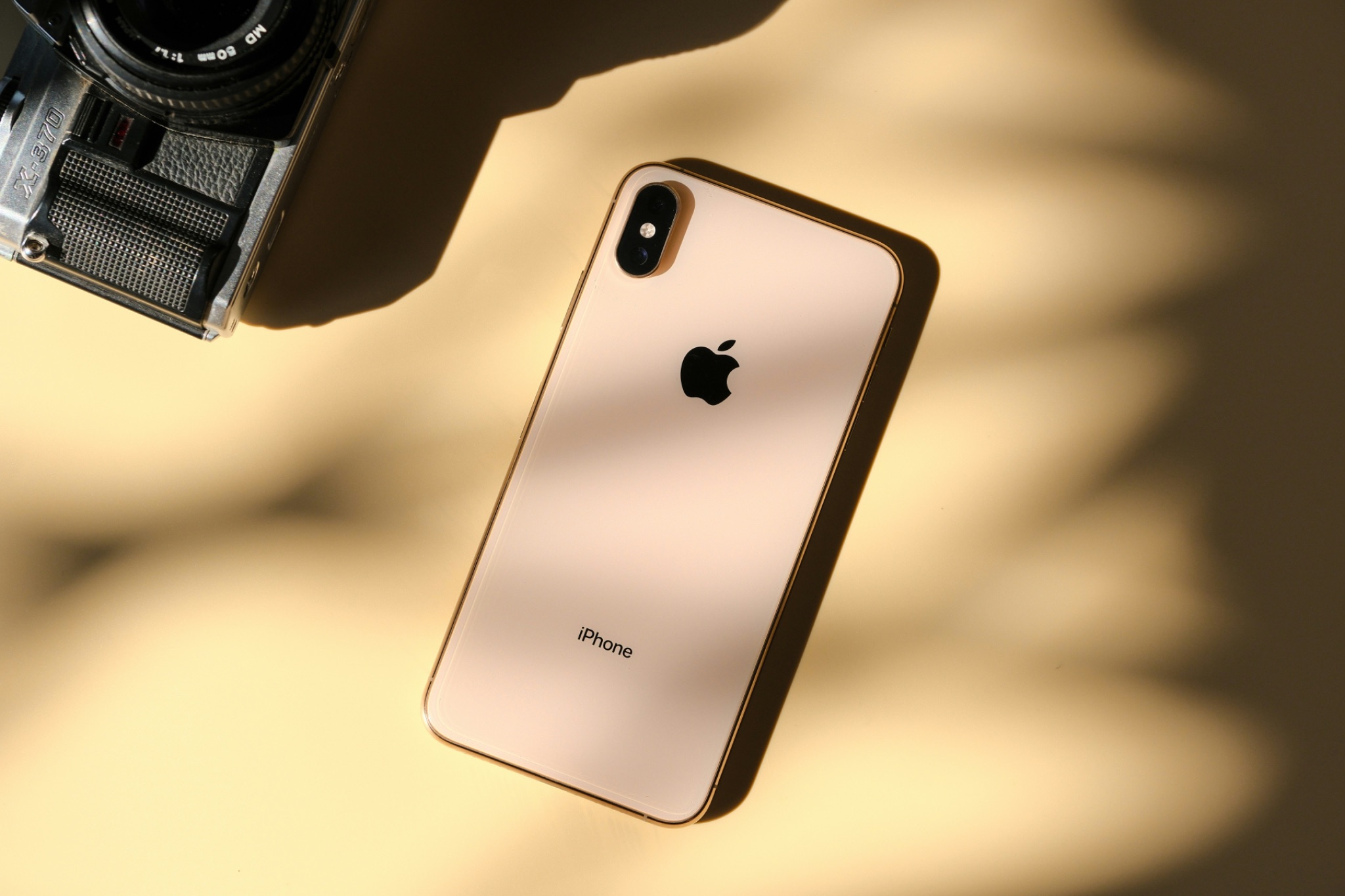 An iPhone with film camera on yellow background