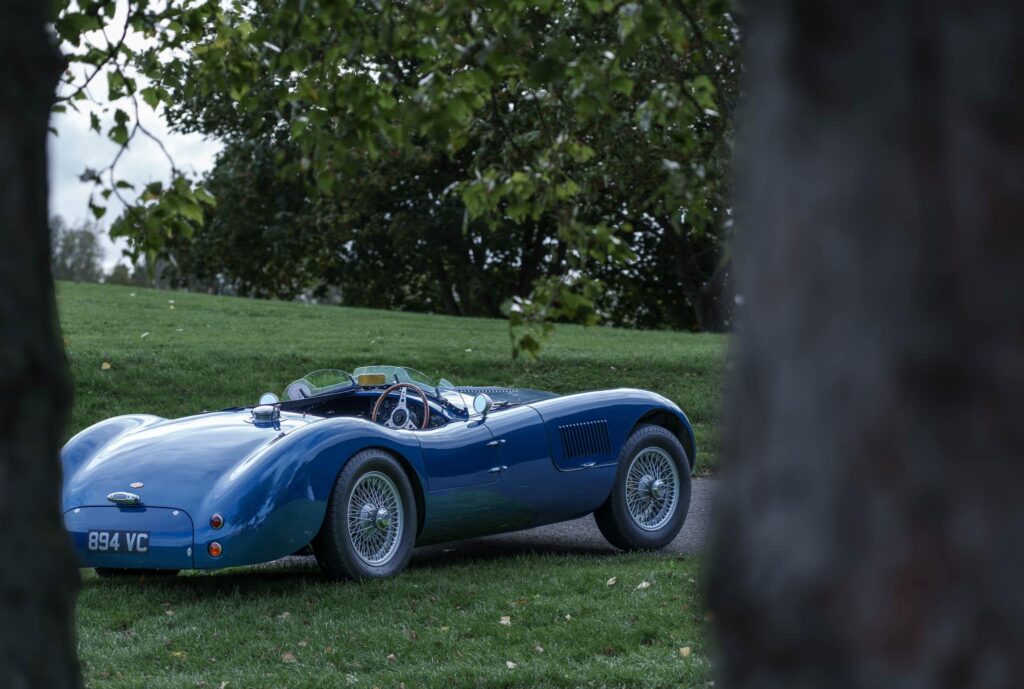 An old Jaguar car seen through trees in England