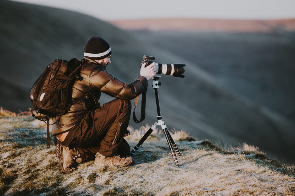 Photographer takes photo on top of a mountain