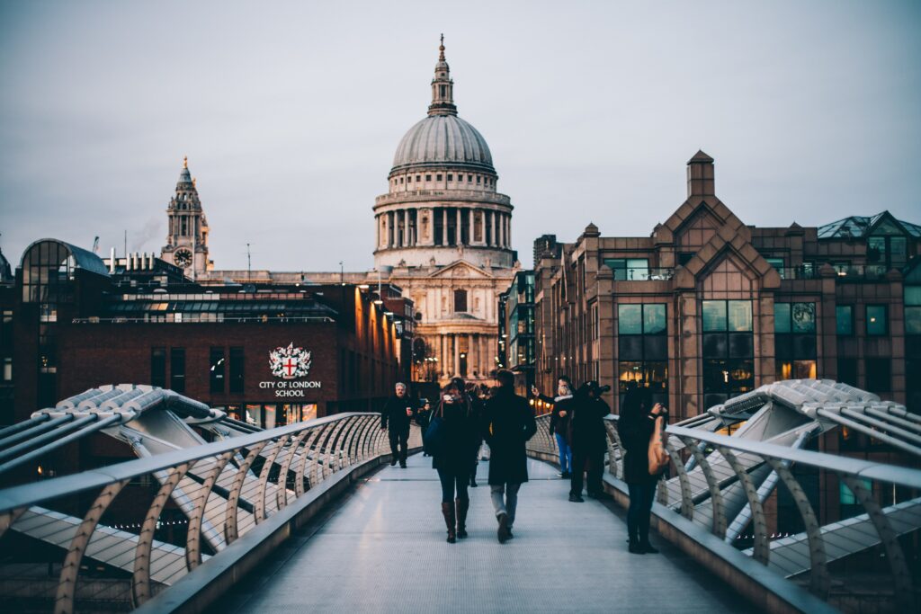 People crossing the Millennium Bridge London with St Pauls behind