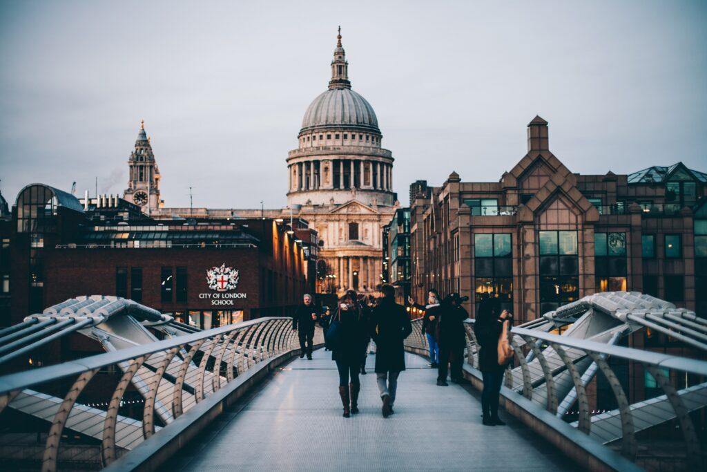 People crossing the Millennium Bridge London with St Pauls behind 