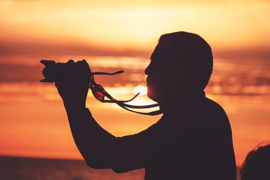 Silhouette of photographer holding camera.