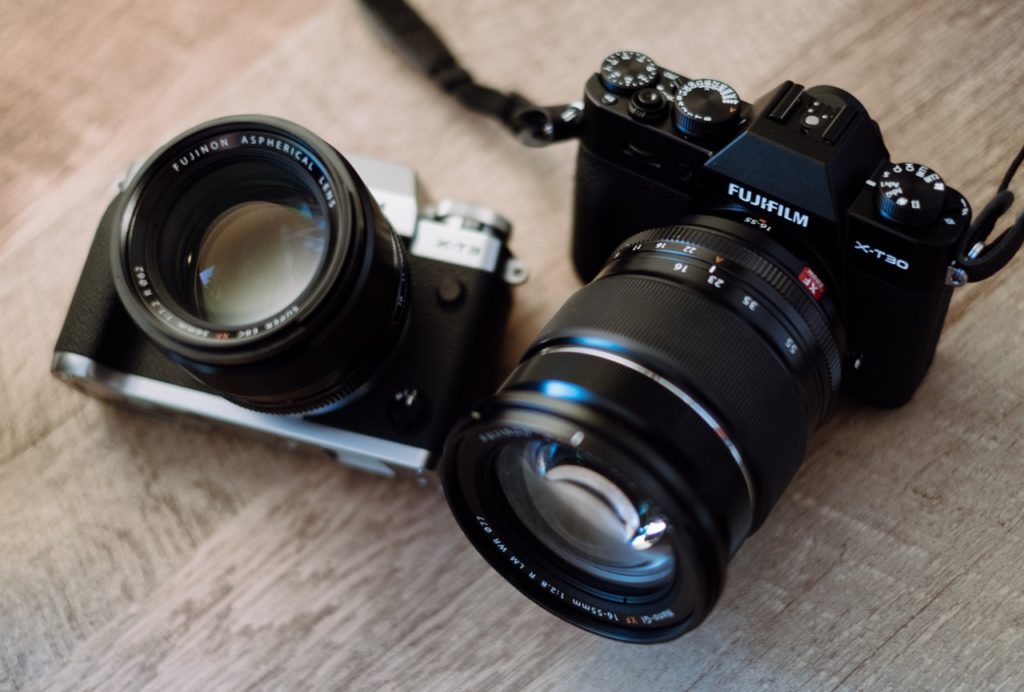 black and gray slr camera and black fujifilm dslr camera