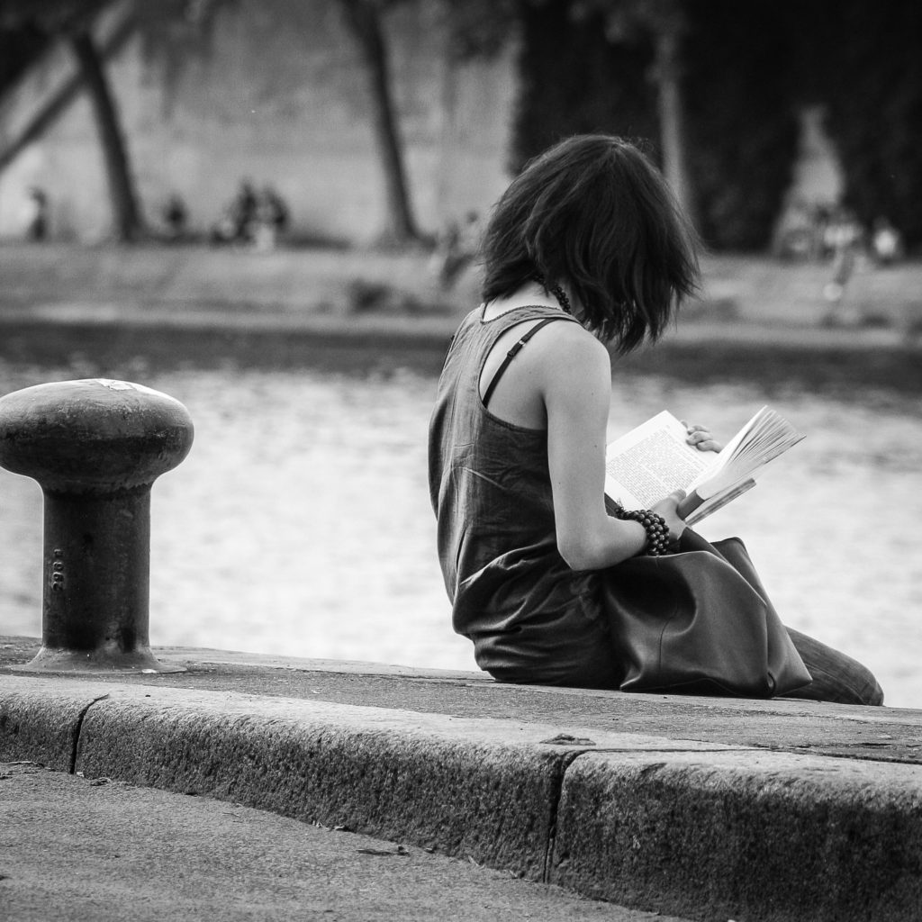 River with girl reading in black and white 