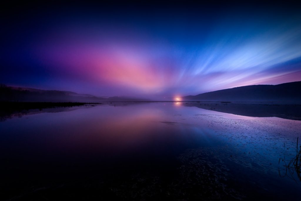 landscape photography of body of water under dramatic sky tips for long exposure