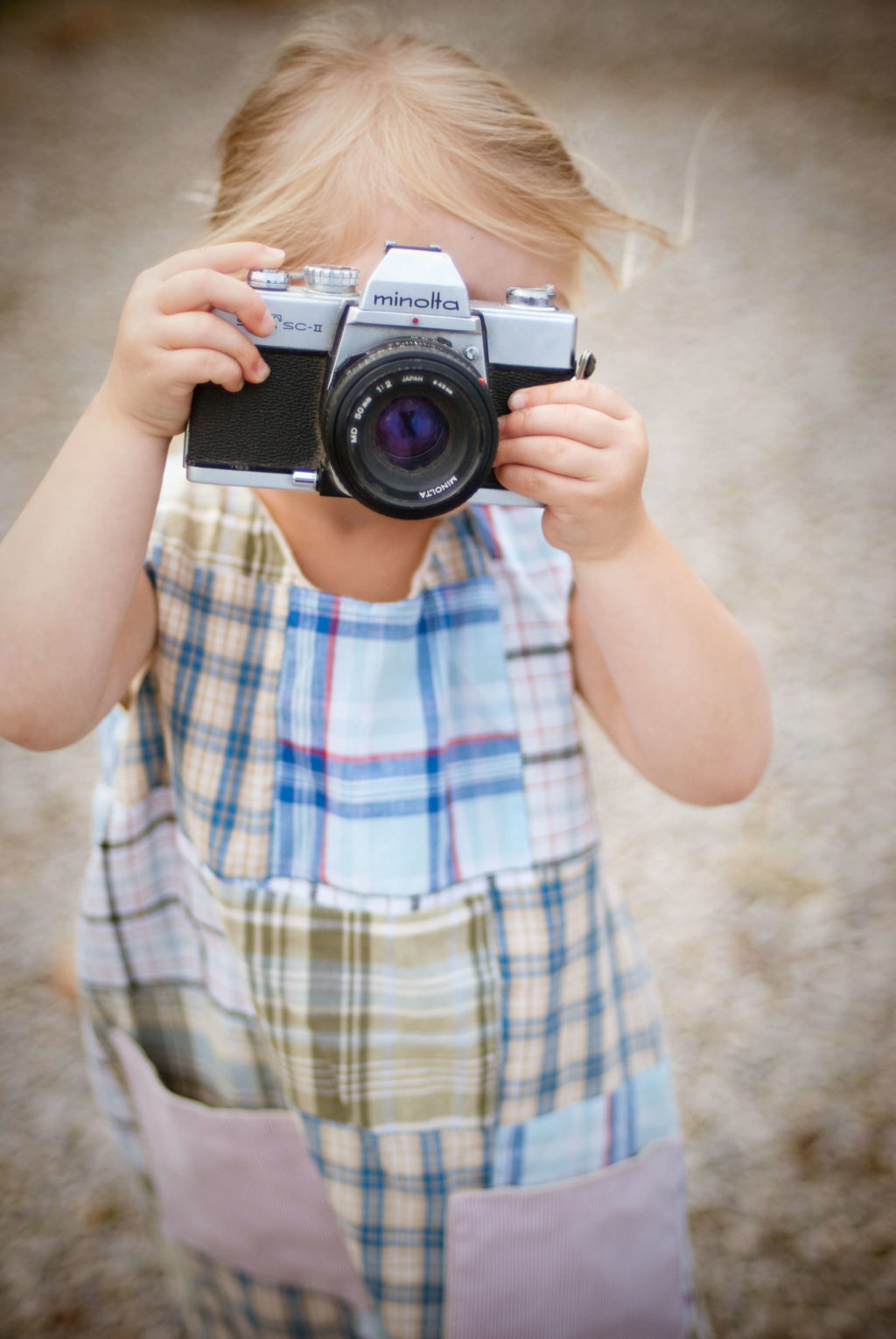 Child holding a minolta camera